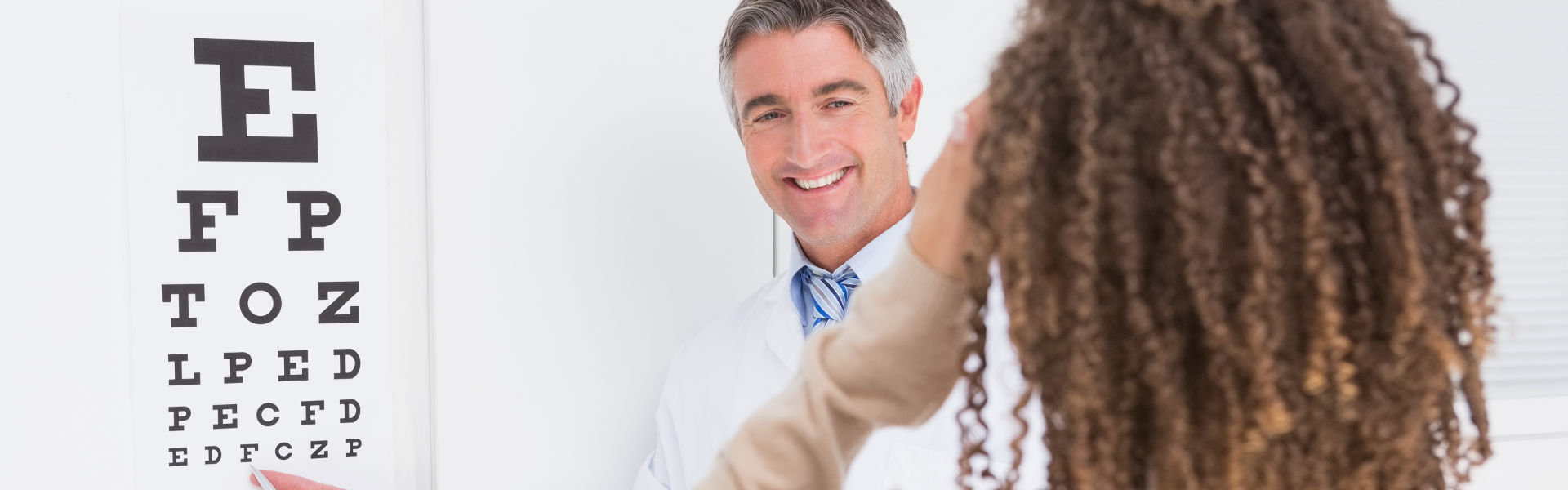 Woman doing eye test with optometrist in medical office