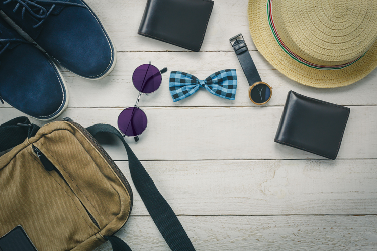 Top view accessoires to travel with man clothing concept. bow tie,wallet on wooden background.watch,sunglasses,bag,hat and shoes on wood table.